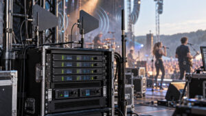 Funkantennen richtig aufstellen: Funkmikrofon-Rack mit zwei Richtantennen, separater IEM-Antenne und Musikern auf einer Konzertbühne.